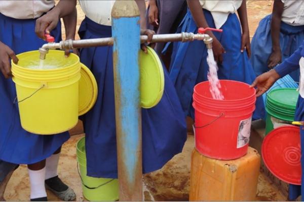 Pupils collect water at a school